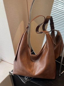 Brown vintage hobo crossbody bag with adjustable wide strap and soft leather texture