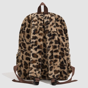 Macro shot showing plush leopard print texture and adjustable brown nylon straps on backpack