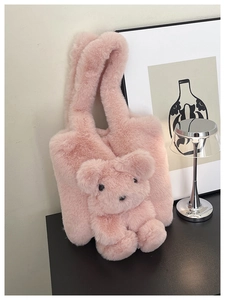 Détail du sac à main rose en peluche avec breloque ours en 3D et anse douce en fausse fourrure