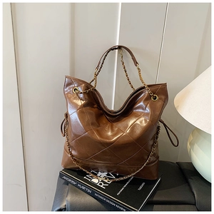 Close-up of brown quilted faux leather tote bag with glossy finish and chain detail