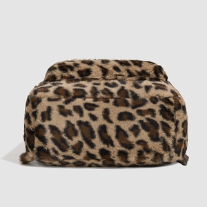 Macro detail of the plush faux fur leopard print texture and soft material of the backpack