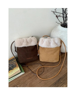 Mini suede bucket bag with plush faux fur trim and embroidered detail in lifestyle setting