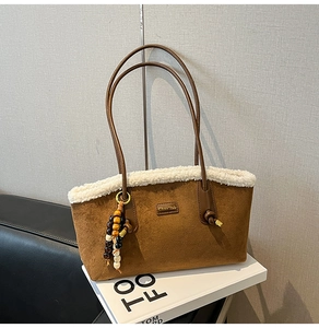 Détail du cabas en daim marron avec bordure en fausse fourrure et breloque en perles
