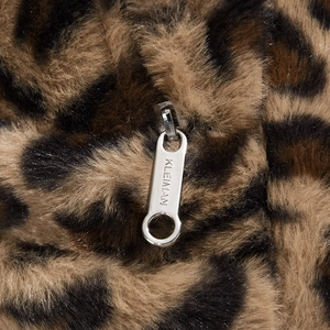 Detailed macro view of the leopard print faux fur texture and silver metal zipper puller