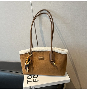 Détail du sac en daim avec bordure en fausse fourrure blanche et breloque en perles