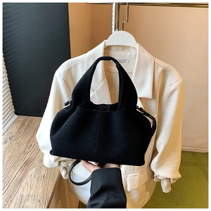 Detailed macro view showing the soft matte texture and gold hardware of the black bucket bag
