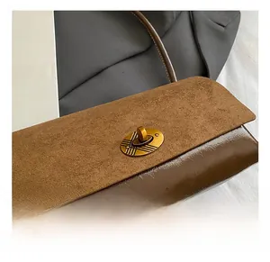 Détail du fermoir doré sur le sac à main en daim marron au style rétro élégant