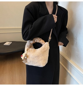 Dettaglio borsa in ecopelliccia beige con consistenza morbida, manici a pieghe e orsetto