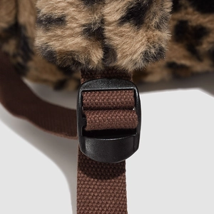 Detail of adjustable strap buckle and nylon webbing on leopard plush backpack