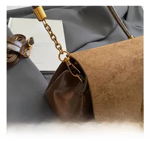 Détail de la chaîne dorée et du crochet à ressort sur le sac à bandoulière marron