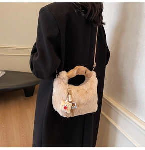 Dettaglio borsa a tracolla in peluche con manico in pelle arricciata e ciondolo toast