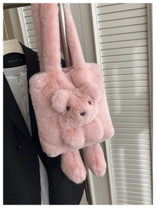 Détail du sac cabas en peluche rose avec un motif d'ours en 3D dans un décor intérieur