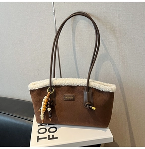 Détail du sac cabas en daim avec bordure en fourrure blanche et breloque en perles