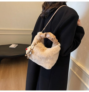 Secchiello in peluche beige con manico arricciato e ciondolo a bambola su cappotto nero