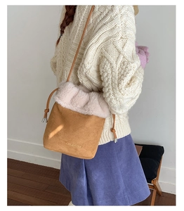 Detail view of caramel suede bucket bag with faux fur trim and drawstring closure