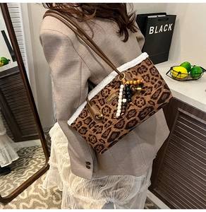 Détail du sac bandoulière léopard avec bordure en fausse fourrure blanche et breloque