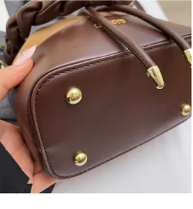 Detail shot of the durable dark brown leather base with four gold metal protective studs