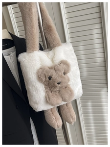 Détail d'un sac cabas en fausse fourrure blanche avec ours en peluche et bandoulière