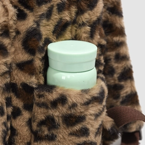 Detail of leopard plush backpack side pocket showing capacity for a small water bottle
