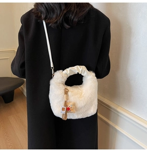 Dettaglio della borsa a mano in peluche bianco con manico increspato e ciondolo cartoon