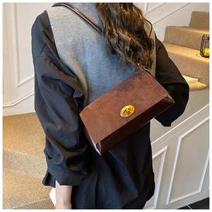 Détail d'un sac à bandoulière vintage marron foncé avec boucle métallique dorée