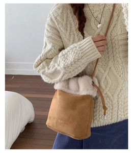 Detail of the brown suede bucket bag featuring plush faux fur trim and drawstring closure