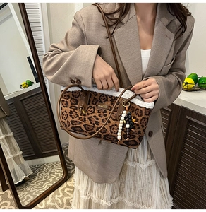 Détail d'un sac cabas léopard avec bordure en peau de mouton et breloque perlée