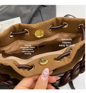 Detail view of the secure magnetic snap and smooth zipper interior of the brown tote bag