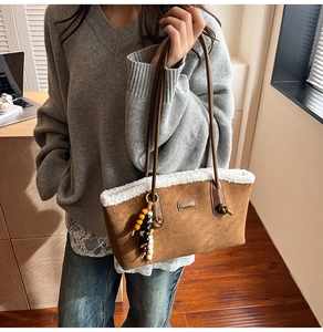 Détail du sac cabas en suède avec bordure en fausse fourrure blanche et logo Cherish