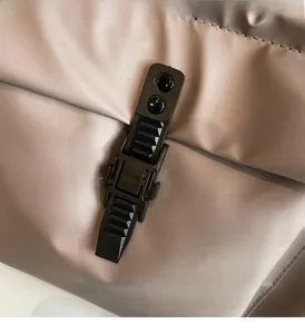 Detail of durable black plastic buckle on khaki fabric with adjustable locking mechanism