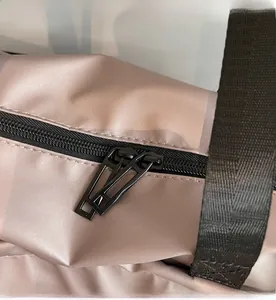 Macro view of smooth metal zippers and nylon handle on lavender travel bag