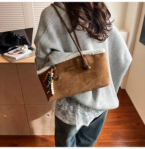 Détail du sac cabas en suède avec bordure en fourrure blanche et pompon en perles