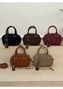 Five assorted colors of leather bowling bags with floral charms and adjustable straps