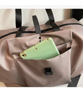 Detail shot of the spacious front pocket on a brown travel bag holding a tablet