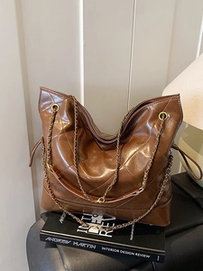 Large dark brown quilted tote bag with golden chain straps and retro glossy finish