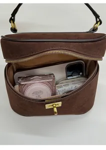 Détail d'un sac à main en daim marron foncé avec fermoir doré et vue intérieure