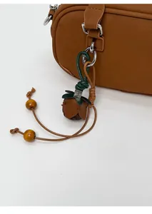 Detail of vintage brown flower bud leather charm with green leaf and wooden beads
