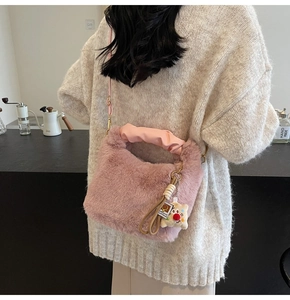 Dettaglio borsa di peluche rosa con manico in raso plissettato e ciondolo orsetto