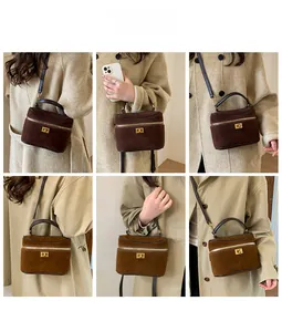 Détails du sac boîte en daim montrant les styles porté épaule et main avec boucles dorées