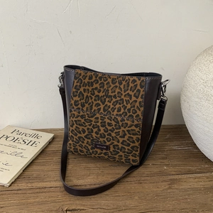 Macro shot of leopard print patchwork shoulder bag with metallic No Filter nameplate