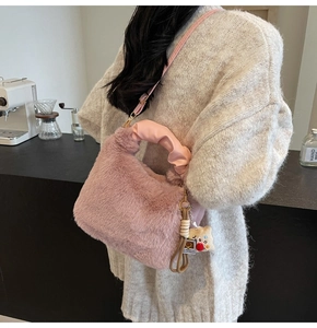 Dettaglio della borsa di peluche rosa con manico in pelle arricciata e ciondolo orso