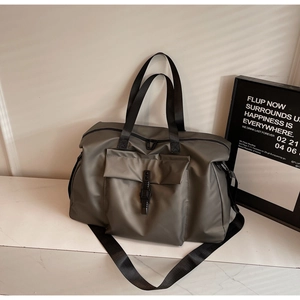 Close-up of travel bag featuring waterproof fabric, front buckle pocket and soft window light