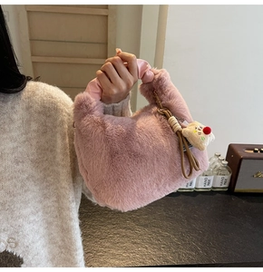 Dettaglio borsa in finta pelliccia rosa con manico in raso arricciato e ciondolo peluche