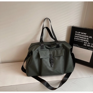 Detail of olive green travel bag showing waterproof fabric and front buckle pocket