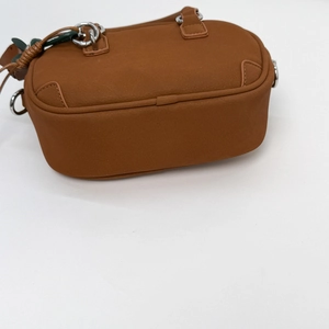 Detailed close-up of brown PU leather shoulder bag with metallic silver side buckles