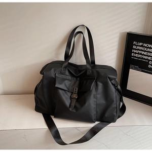 Detail of black large capacity travel bag featuring durable nylon and adjustable straps