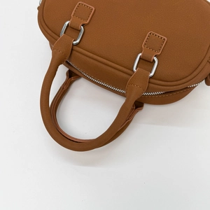 Close-up of the silver zipper and dual handles on a vintage brown Boston handbag