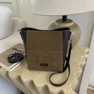 Detail of vintage bucket bag with brown leather and green suede contrast stitching