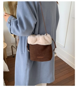 Detail of suede bucket bag with faux shearling trim and CHGBYUAN embroidery