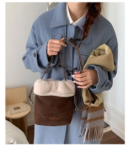 Brown suede bucket bag with cream faux fur trim worn with a blue wool coat